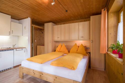 a bedroom with a large bed with yellow pillows at Rene zentrales Studio Appartement - by NV-Appartements in Kirchberg in Tirol