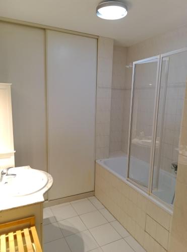 une salle de bain avec une douche, une baignoire et un lavabo dans l'établissement Appartement 2 chambre et terrasse, à Caux