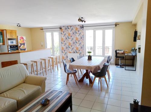 un salon avec un canapé, une table et des chaises dans l'établissement Appartement 2 chambre et terrasse, à Caux