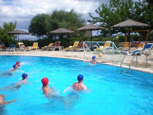 a group of people playing volleyball in a swimming pool at Porto Skala Village Hotel in Skala Kefalonias