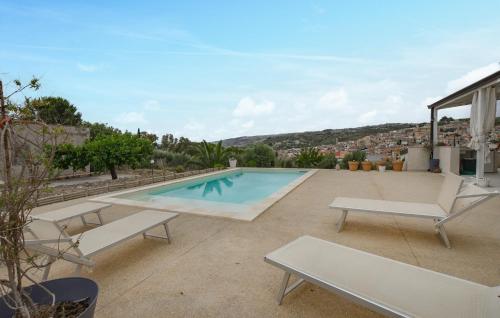 a swimming pool on a roof with two lounge chairs at Cozy Home In Giarratana With Wifi in Giarratana