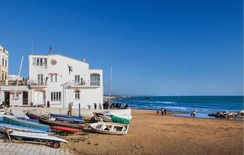 a group of boats on a beach next to a building at Cozy Home In Giarratana With Wifi in Giarratana