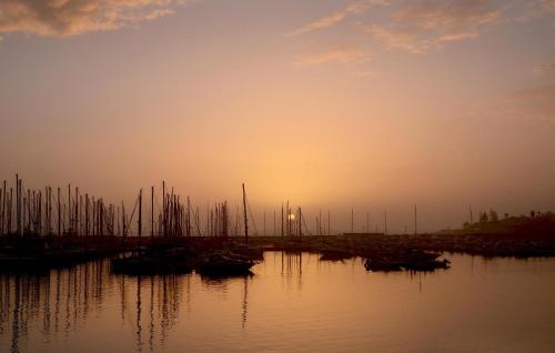a group of boats sitting in the water at sunset at Cozy Home In Giarratana With Wifi in Giarratana