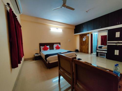 a bedroom with a bed with red pillows at CHETAN INN HOTEL in Bhubaneshwar