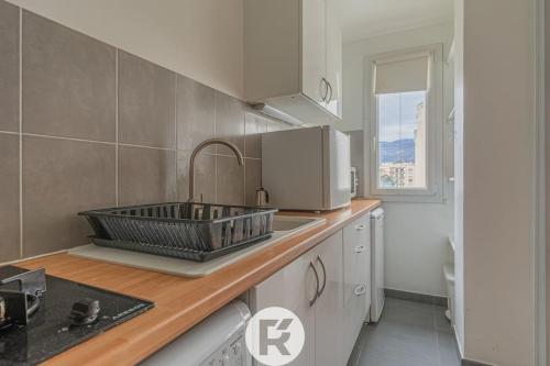 une cuisine avec un évier et un plan de travail dans l'établissement R'Apparts T1 Petit Safari, à Grenoble