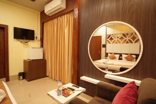 a living room with a large mirror in a hotel room at PS Luxury Hotel in Baharampur