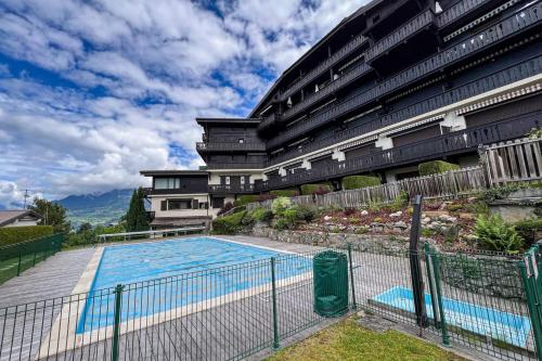 un immeuble avec une piscine devant un immeuble dans l'établissement Comfortable studio with pool and view, à Saint-Gervais-les-Bains