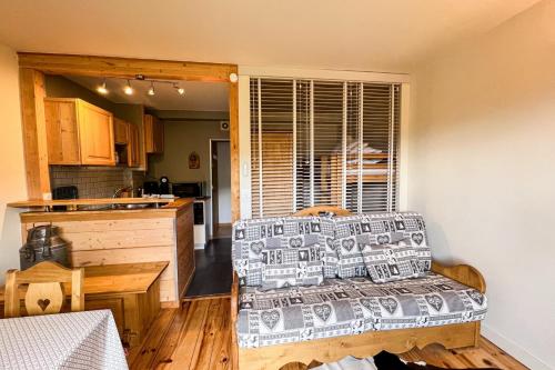 un salon avec un canapé et une cuisine dans l'établissement Comfortable studio with pool and view, à Saint-Gervais-les-Bains