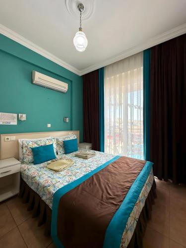 a bedroom with a large bed with blue walls at Villa Dolunay Apart Hotel in Dalyan