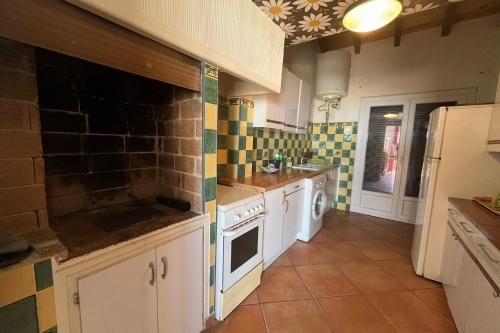 - une cuisine avec des appareils blancs et du carrelage sur les murs dans l'établissement Spacious house in front of the sea of Fleury, à Fleury
