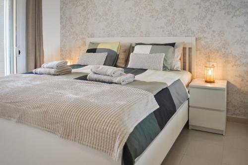 een slaapkamer met een groot bed met handdoeken erop bij Relax Sunny Golf Apartment in San Miguel de Abona