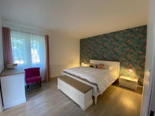 a bedroom with a bed and a red chair at Domaine Labatut in Tourrenquets