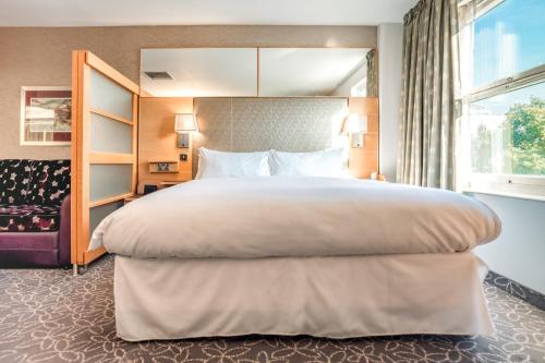 a hotel room with a large bed and a window at Club Quarters Hotel Covent Garden Holborn, London in London