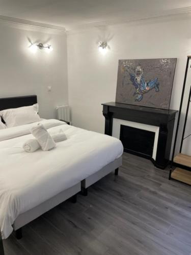 une chambre blanche avec un lit et une cheminée dans l'établissement Appartement design au coeur de Paris, à Paris