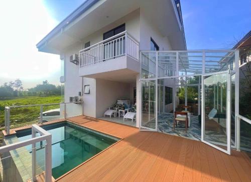 a house with a deck and a swimming pool at Experience Elements CherryBlossoms, Pool,SunRoom in Silang
