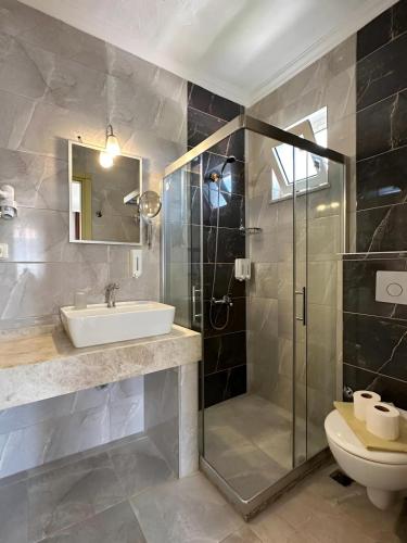 a bathroom with a shower and a sink and a toilet at Villa Dolunay Apart Hotel in Dalyan