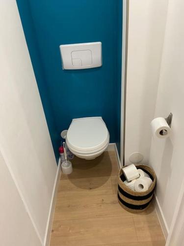 Elle comprend une petite salle de bains pourvue de toilettes et d'un mur bleu. dans l'établissement Superbe T2 dans Nice avec balcon et parking, à Nice
