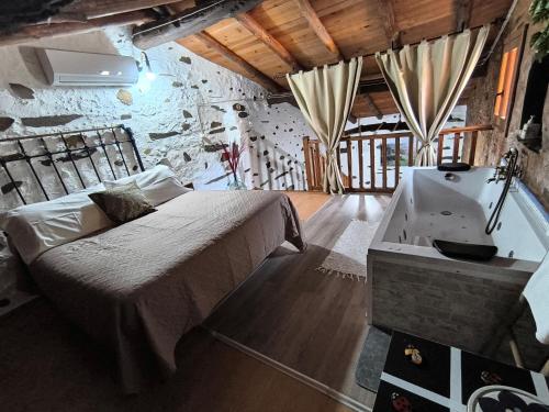 a bedroom with a bed and a bath tub at Casa rural La calleja de las hurdes TRCC00555 in Sauceda