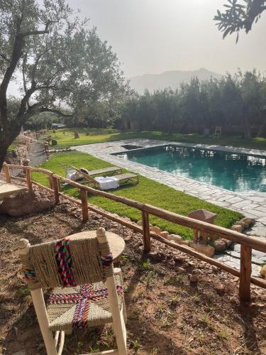 a chair sitting in front of a swimming pool at Bin Jbal Resort in Ouirgane