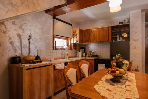 a kitchen with a table with a bowl of fruit on it at Villa Brda in Petrovac na Moru