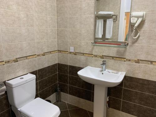 a bathroom with a toilet and a sink and a mirror at Sahil Boutique Hotel in Baku