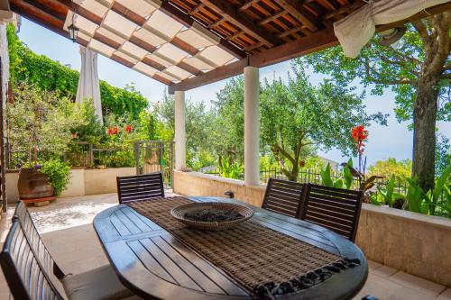 a patio with a table and chairs on a patio at Villa Brda in Petrovac na Moru