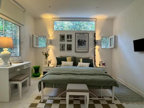 a bedroom with a bed and a desk and a window at Gardenhouse in Rafina