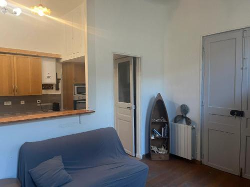 un salon avec un canapé bleu et une cuisine dans l'établissement Studio confortable à Marseille - 25 m² - Proche centre-ville, à Marseille