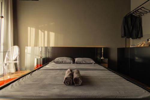 a bed with two pairs of shoes sitting on it at ETERN Apart-Hotel II in Pristina