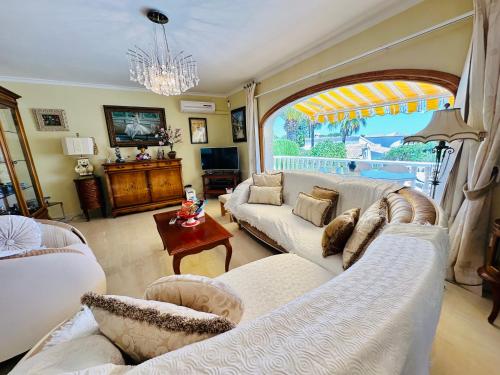 a living room with white furniture and a large window at Casa Sofia in Calpe