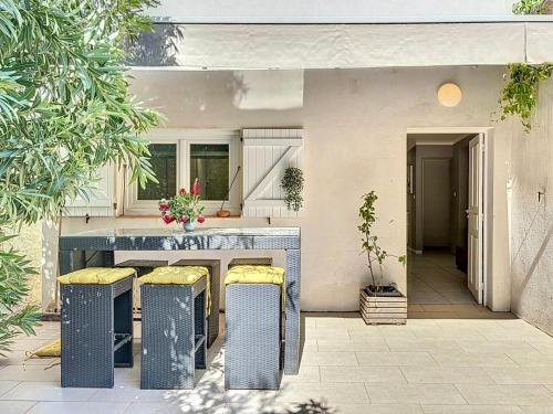 - une cuisine avec un comptoir et des tabourets dans la cour dans l'établissement Maison familiale - À une minute du front de mer - Les Frères de la Loc', à Pietrosella