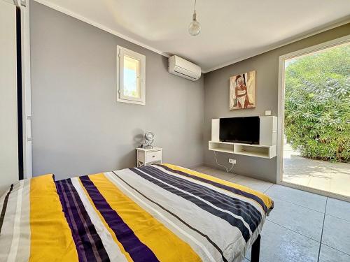 une chambre avec un lit et une télévision à écran plat dans l'établissement Maison familiale - À une minute du front de mer - Les Frères de la Loc', à Pietrosella