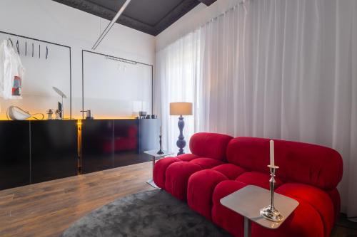 a living room with a red couch and a table at ETERN Apart-Hotel II in Pristina