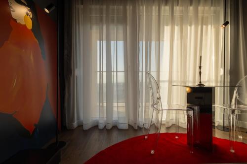 a living room with a glass table and a window at ETERN Apart-Hotel II in Pristina
