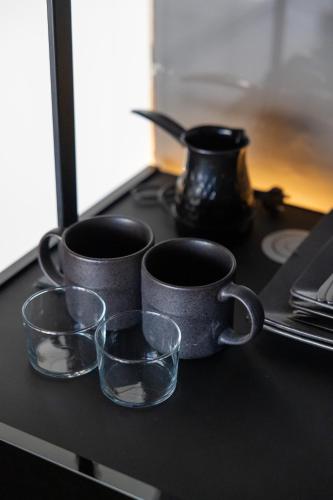 a group of cups sitting on a counter with a table at ETERN Apart-Hotel II in Pristina