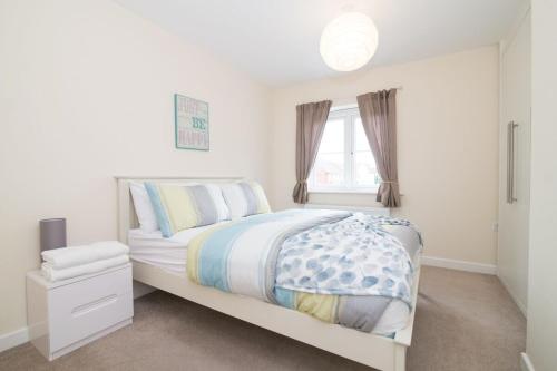 a white bedroom with a bed and a window at Lovely Two Bed detached house with Parking in Tipton