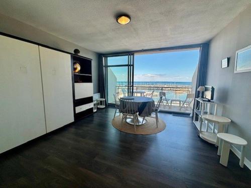 - un salon avec une table et une vue sur l'océan dans l'établissement Quiberon - Studio 33m², 3 pers, Balcon vue mer, Parking, Animaux admis - FR-1-478-86, à Quiberon