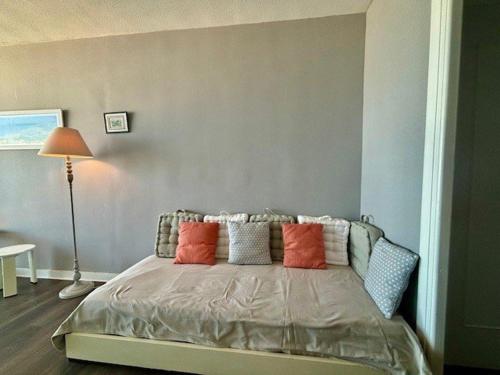 une chambre avec un lit avec des oreillers colorés dessus dans l'établissement Quiberon - Studio 33m², 3 pers, Balcon vue mer, Parking, Animaux admis - FR-1-478-86, à Quiberon