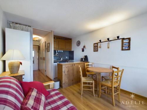 un salon avec une table et une cuisine dans l'établissement Studio Sud 4 pers, balcon, à 50m des pistes et 200m des commerces, idéal pour familles - FR-1-398-629, à Montvalezan