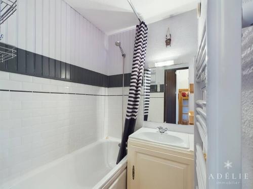 une salle de bain avec une baignoire, un lavabo et une douche dans l'établissement Studio Sud 4 pers, balcon, à 50m des pistes et 200m des commerces, idéal pour familles - FR-1-398-629, à Montvalezan