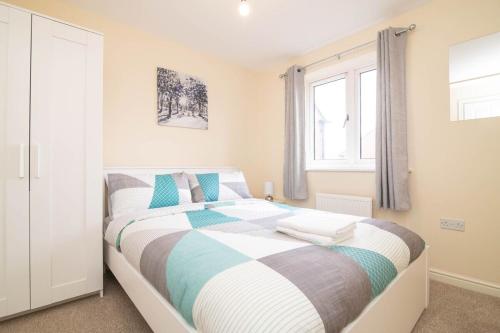 a bedroom with a bed with blue and white sheets at Quiet and Lovely 3-bed house parking and garden in Wolverhampton