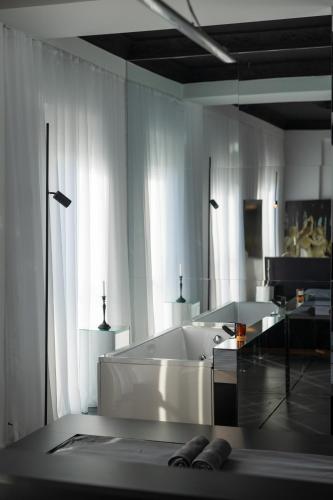 a white bathroom with a tub and a glass table at ETERN Apart-Hotel II in Pristina