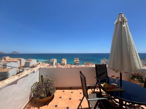 a patio with a table and an umbrella and the ocean at Casa Asplund, casco antiguo con vistas al mar in Altea