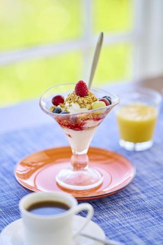 a dessert in a glass bowl on a plate with a cup of coffee at Highcliffe House in Lynton
