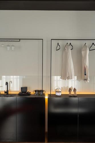 a kitchen with a black counter with clothes on display at ETERN Apart-Hotel II in Pristina