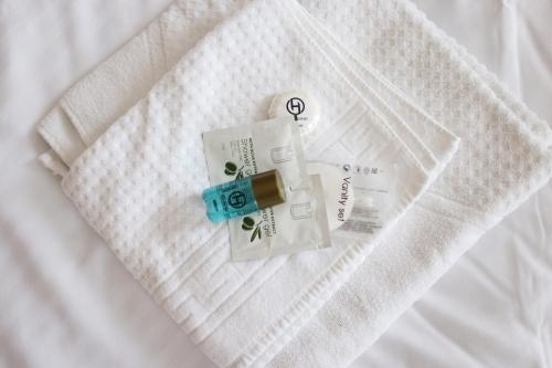 a bottle of medicine on a white blanket at Mythos Hotel Oranienburg in Oranienburg