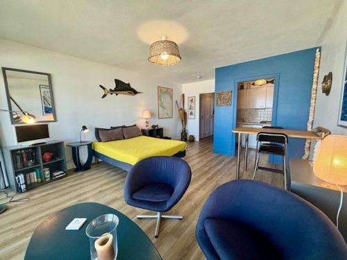 une chambre avec un lit et des chaises dans l'établissement Quiberon - Studio rénové 33m² avec Balcon, Parking et Animaux acceptés - FR-1-478-121, à Quiberon