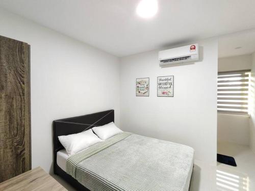 a white bedroom with a bed and a air conditioner at Kafaz2-Kpg Patingan 3Bedroom 3 Bathroom -first floor in Kuching