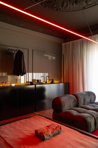 a room with a couch and a kitchen with a red light at ETERN Apart-Hotel II in Pristina