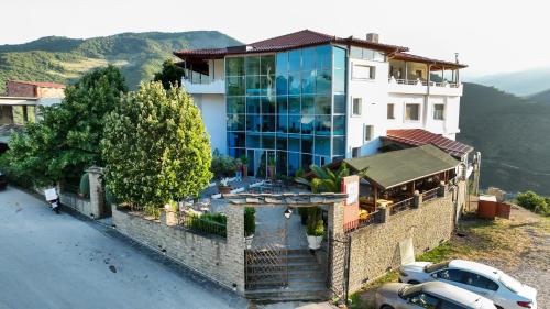 a building with a car parked in front of it at Hotel Kanione in Çorovodë